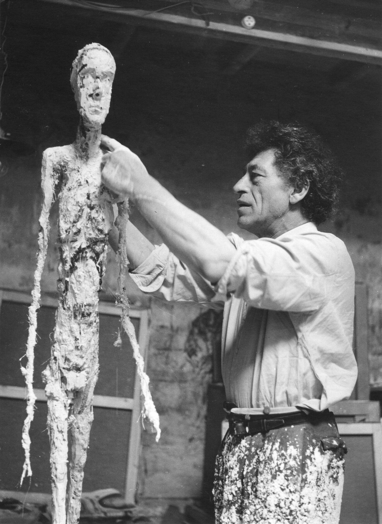 Ernst Scheidegger, Alberto Giacometti Working on the Plaster of the “Walking Man,” c. 1959, silver print on paper, Archives, Fondation Giacometti. © 2022 Artists Rights Society (ARS), New York / ProLitteris, Zurich