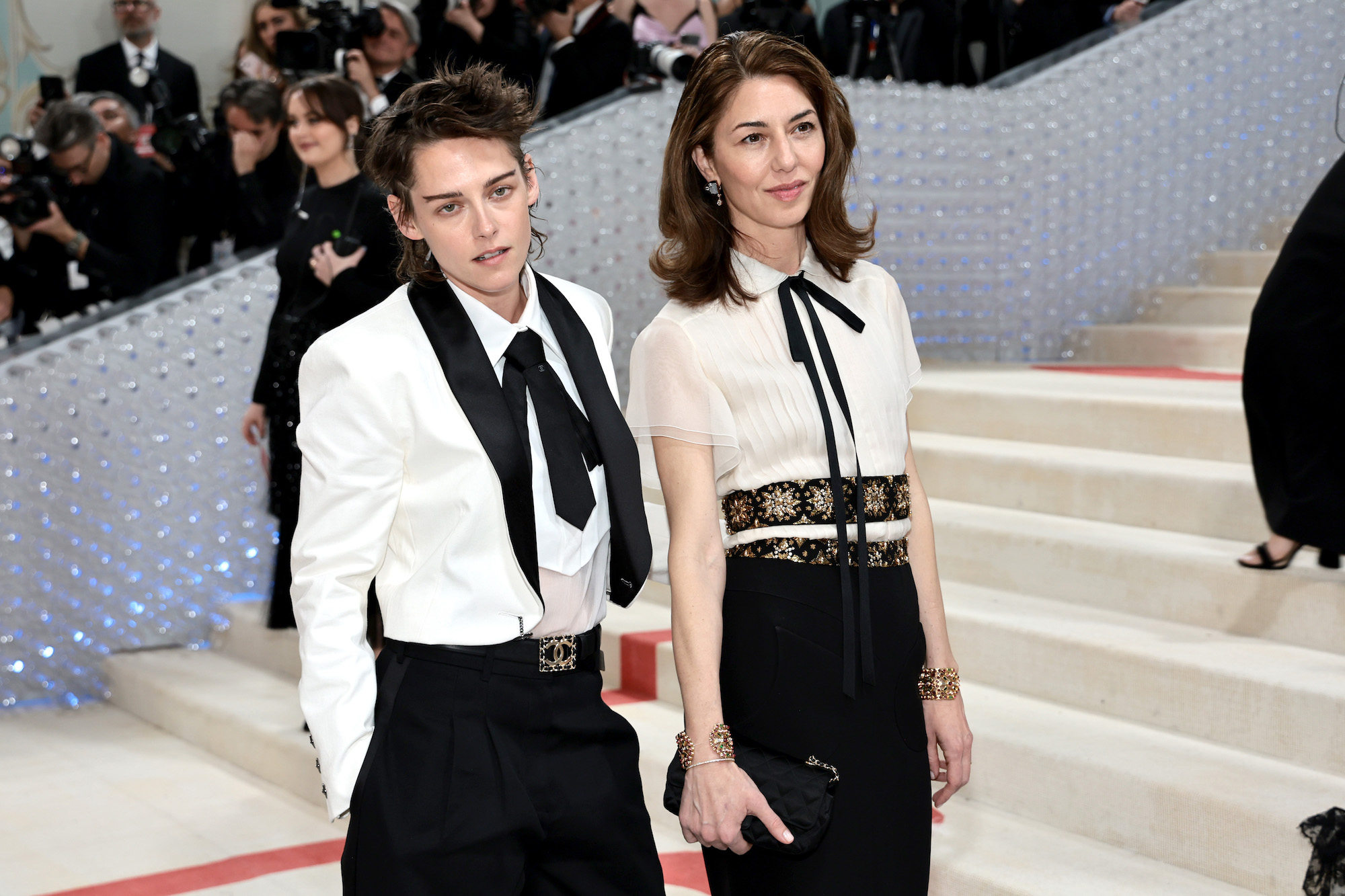 Kristen STEWART, CHANEL Ambassador, wore a white cotton drill jacket with a white silk chiffon blouse and black cotton gabardine pants, look 5, from the Cruise 2016/17 collection. CHANEL tie, belt and shoes. CODE COCO watch. Steel and one black dial set with a princess-cut diamond - CHANEL Watches CHANEL Makeup Sofia COPPOLA, CHANEL Ambassador, wore a white organza pleated blouse with a long black silk crêpe skirt embellished with silk crêpe belt embroidered with golden sequins and imitation pearls, look 43, from the Haute Couture Spring-Summer 2001 collection. CHANEL bag and shoes. PERSANE cuffs in 18K yellow gold, pink tourmalines, tsavorites, rubellites and diamonds CHANEL High Jewelry. FLEUR DE LAQUE earrings in 18K white gold, yellow gold, mother-of-pearls and diamonds CHANEL High Jewelry. CHANEL Makeup